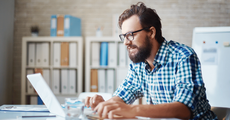 man sat at desk with laptop