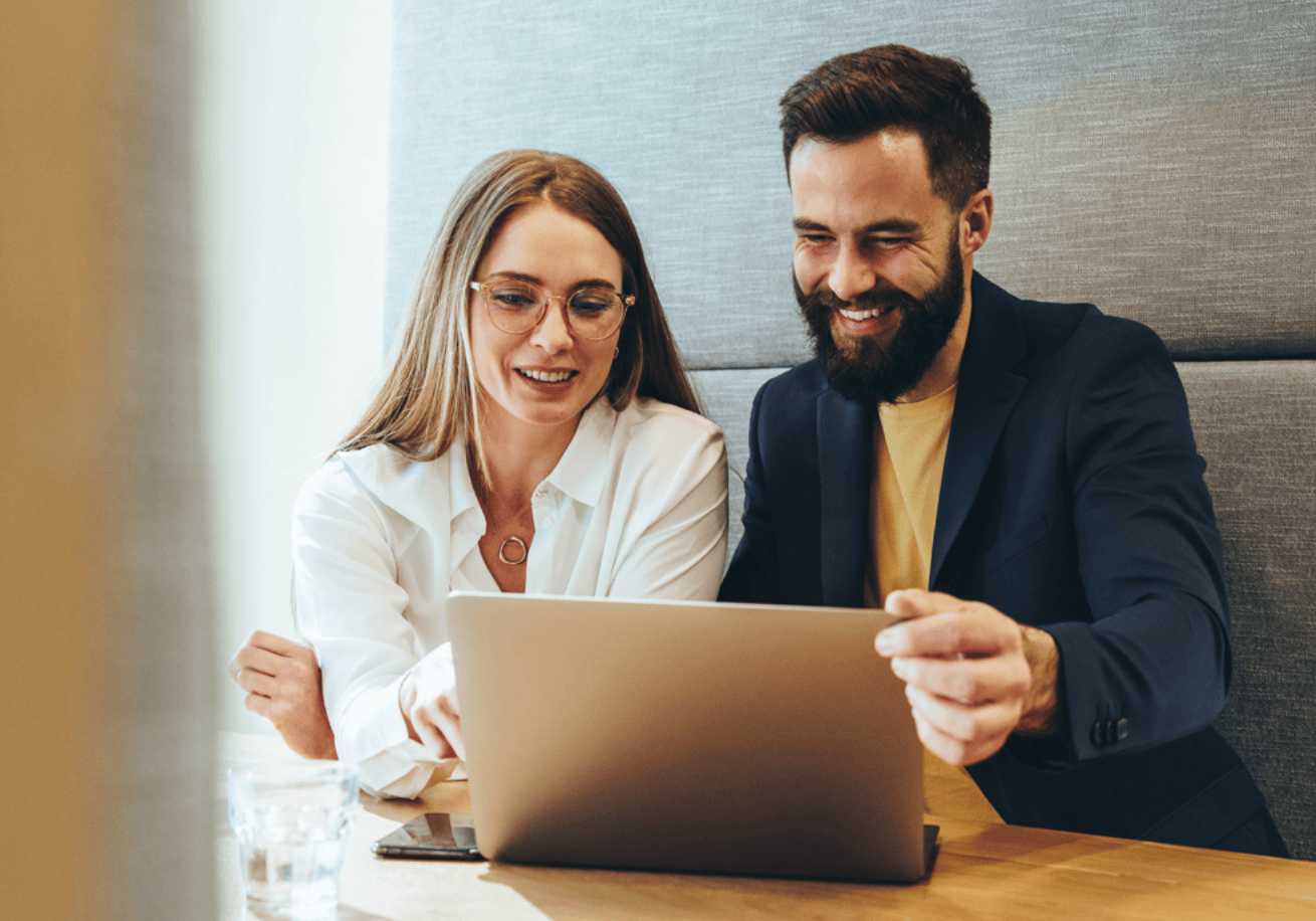 two people sat behind laptop