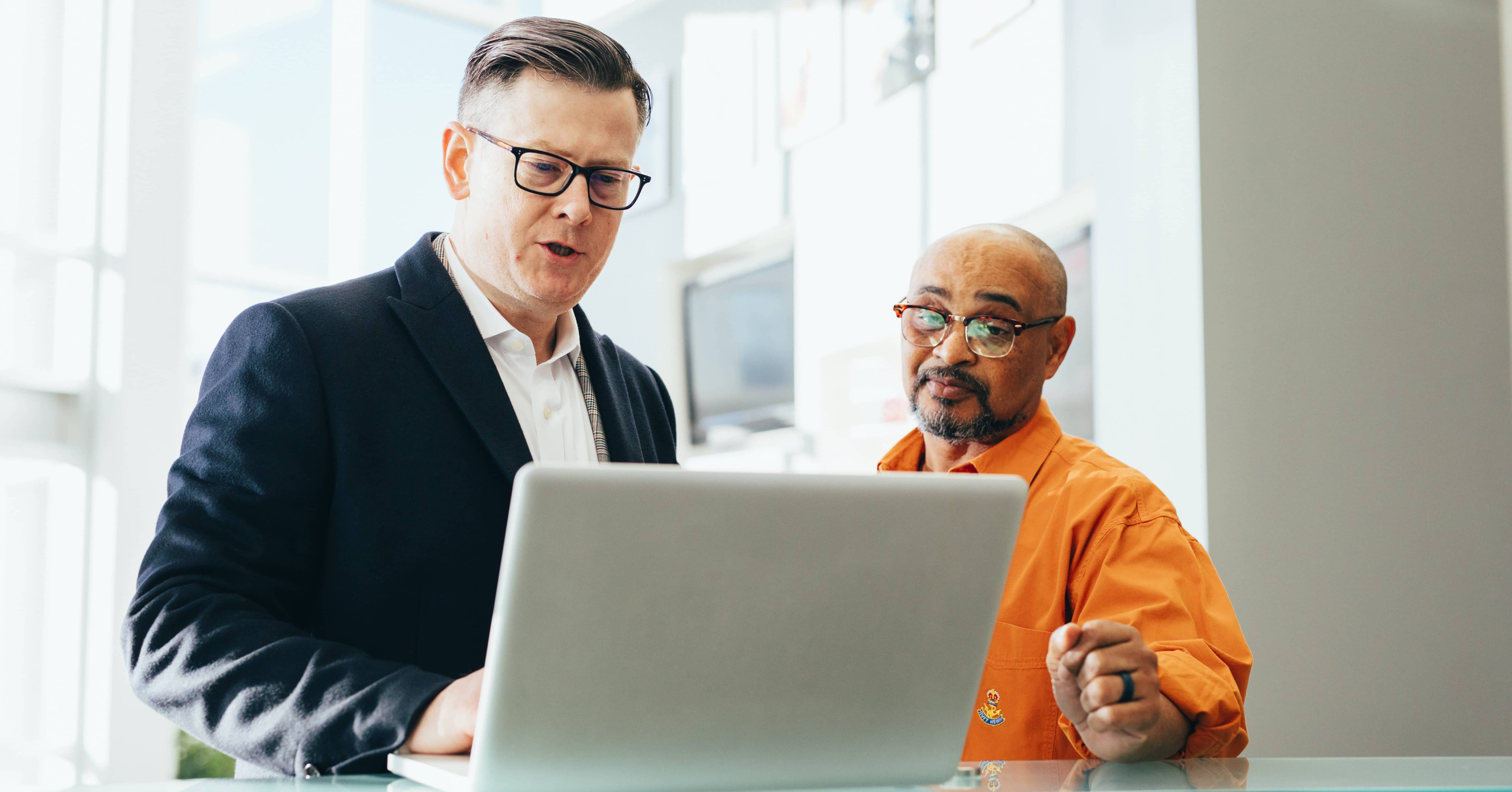 two men stood with laptop